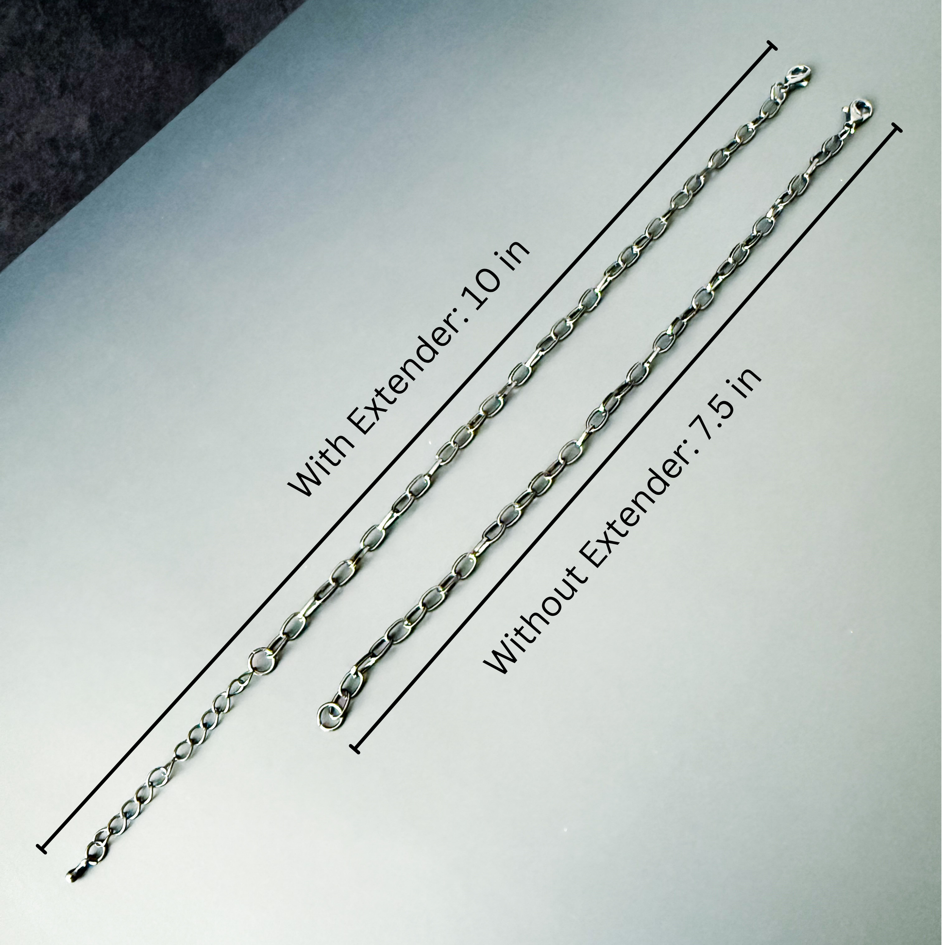 Two silver bracelets with measurements on a gray background