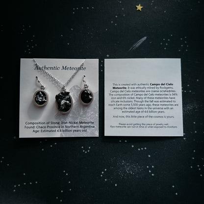 Meteorite jewelry set with cards on a dark background