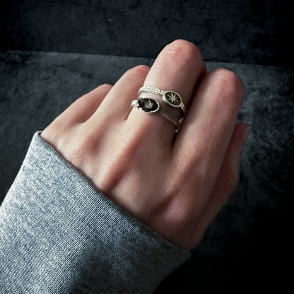 Hand wearing the ring on a dark background