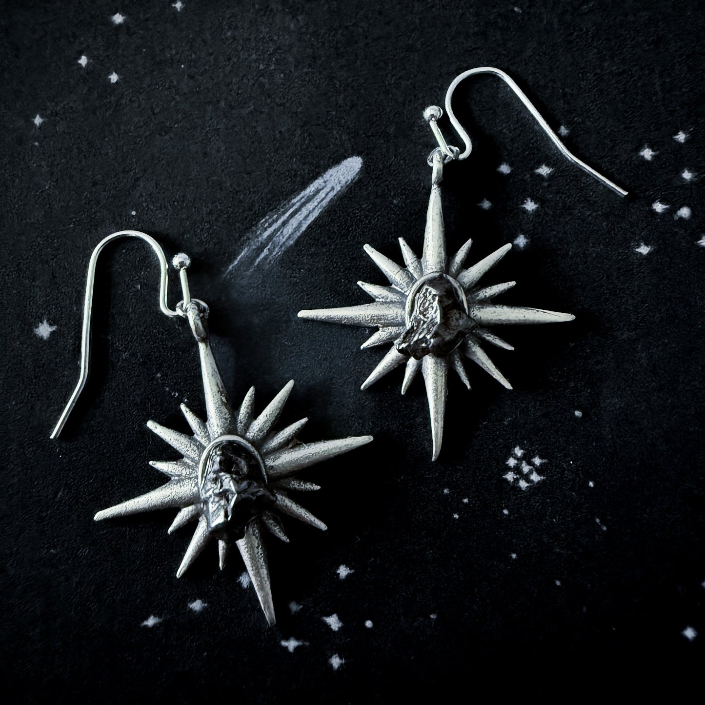 Supernova Starburst Dangle Earrings with Authentic Meteorite on a dark space background