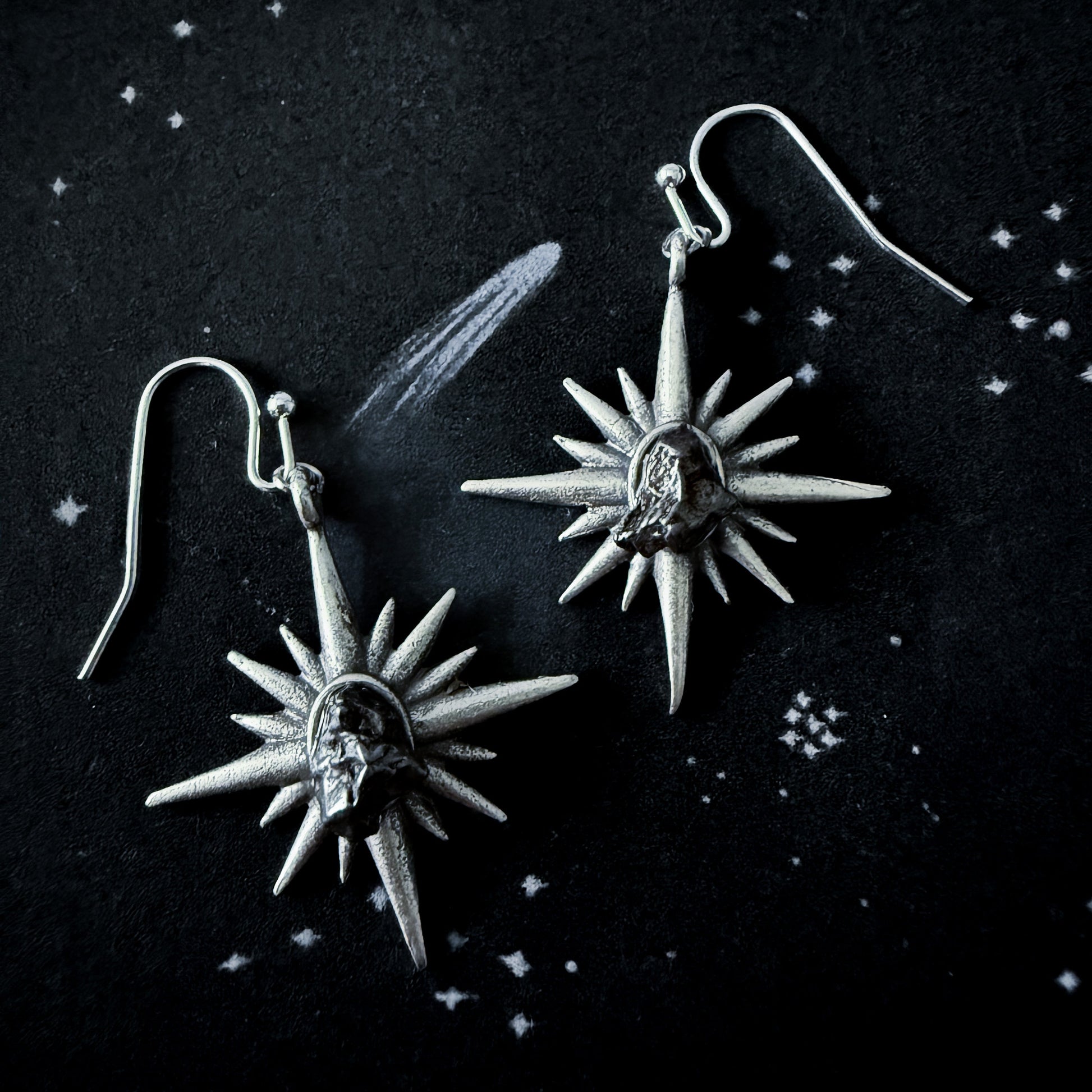 Supernova Starburst Dangle Earrings with Authentic Meteorite on a dark space background