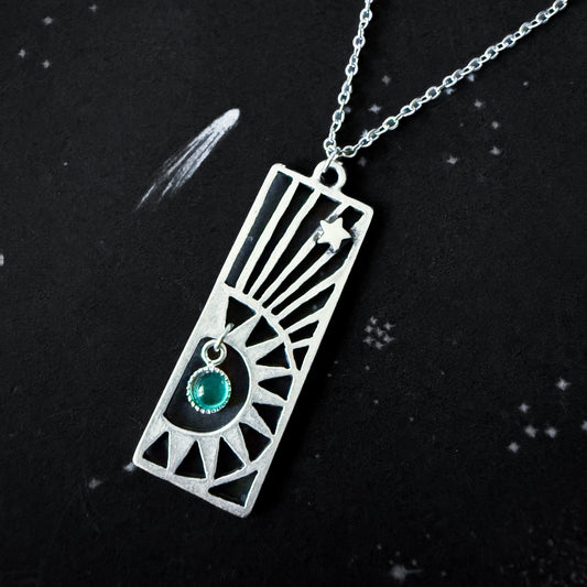 Silver necklace with a rectangular pendant featuring a birthstone on a black background