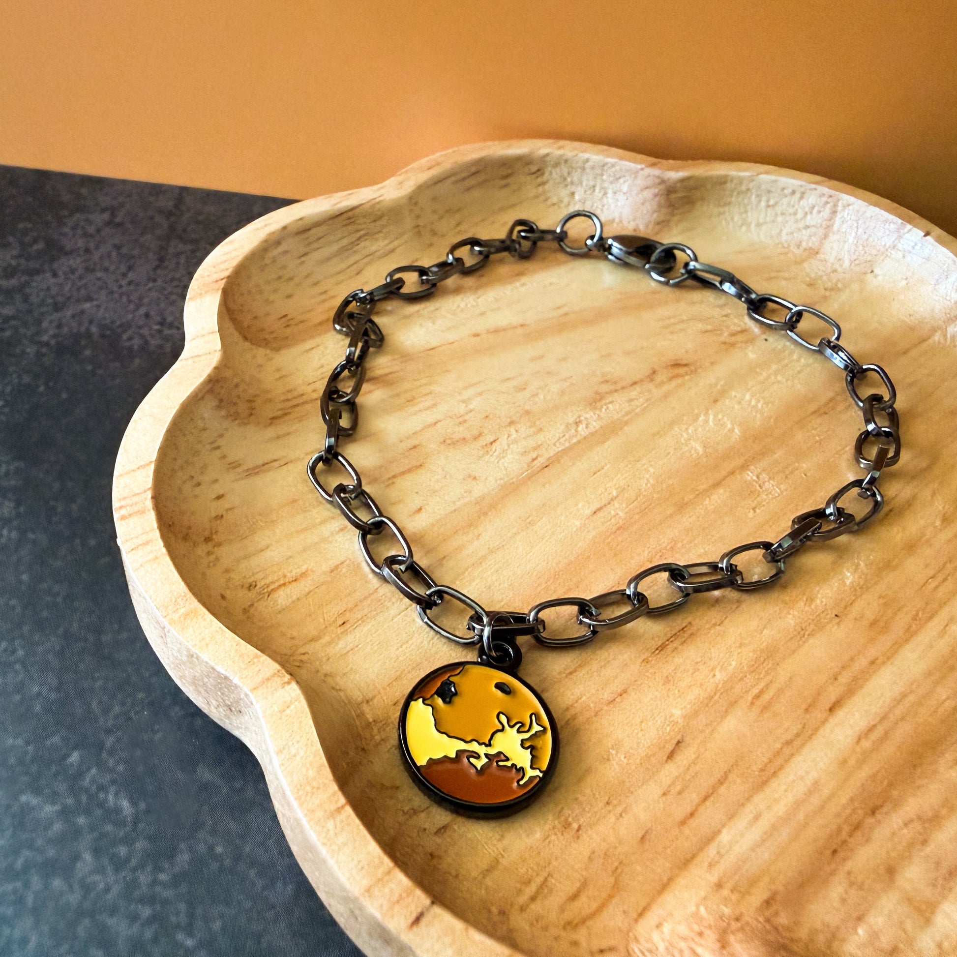 Bracelet with a pendant on a wooden dish
