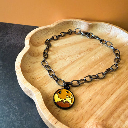 Bracelet with a pendant on a wooden dish