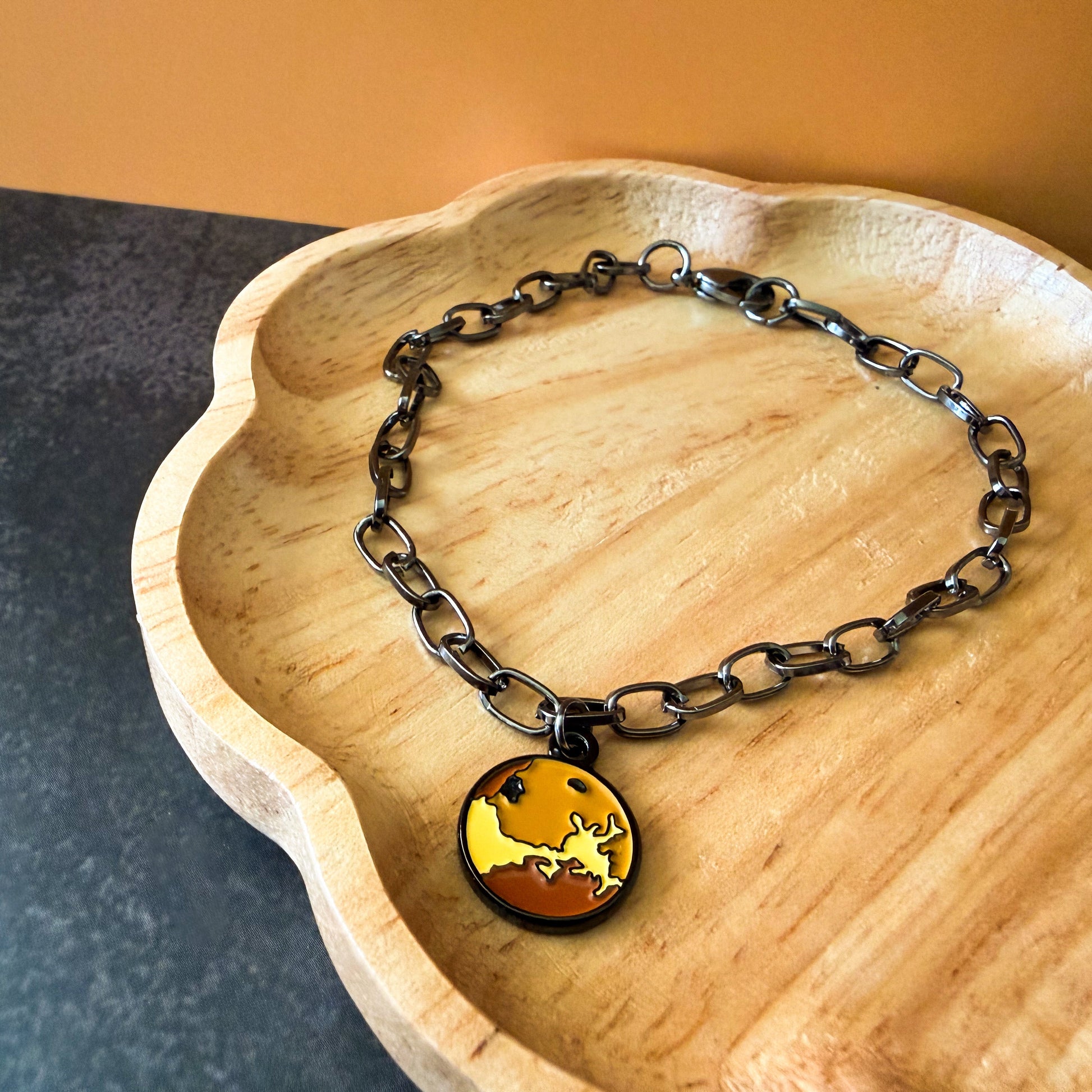 Bracelet with a pendant on a wooden dish