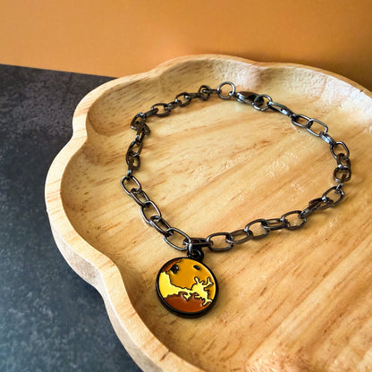 Bracelet with a pendant on a wooden dish