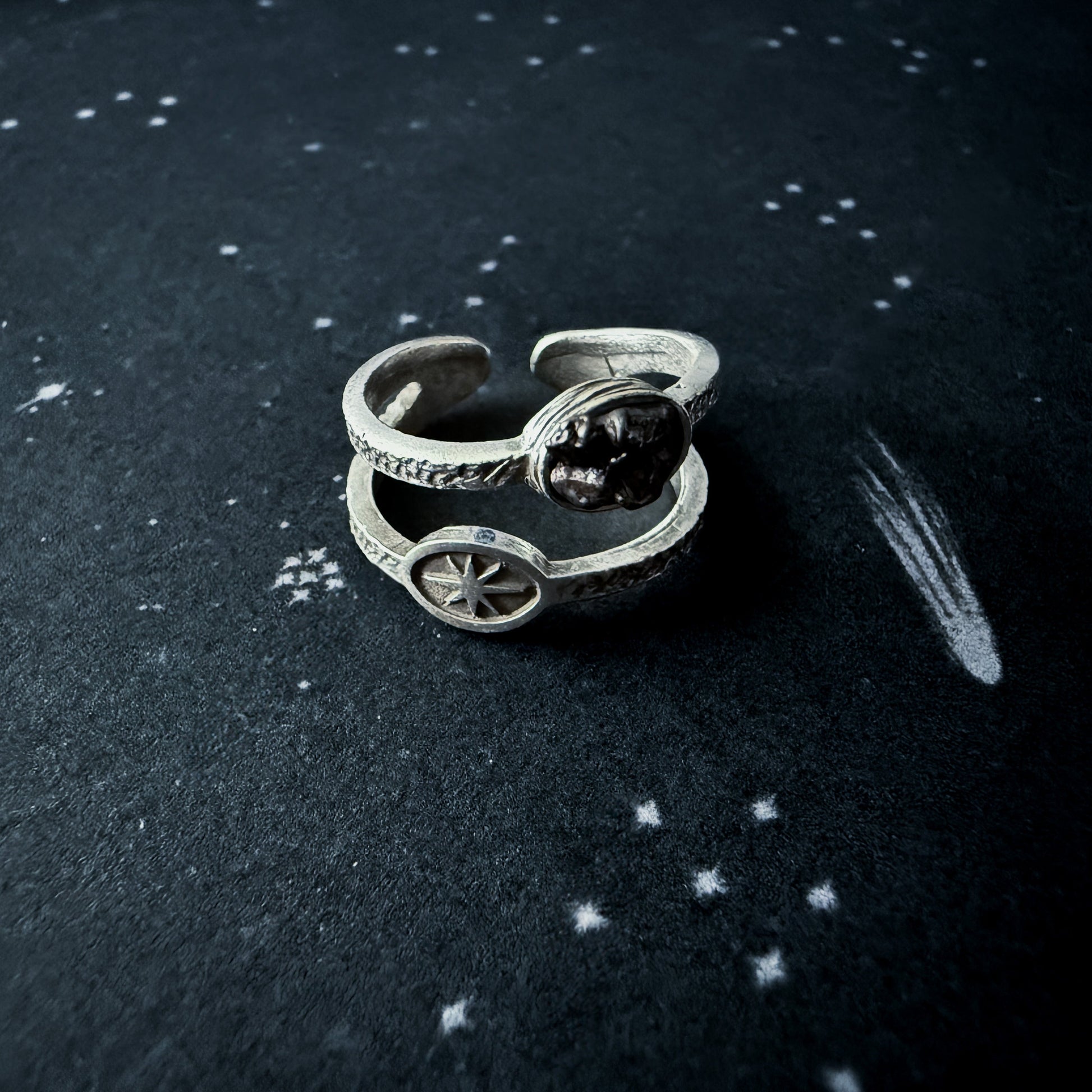 Silver ring with meteorite on a dark surface