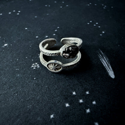 Silver ring with meteorite on a dark surface