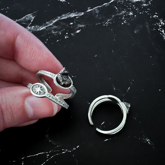 Silver rings on a black marble surface