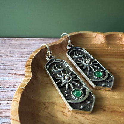Silver earrings with birthstones on a wooden surface