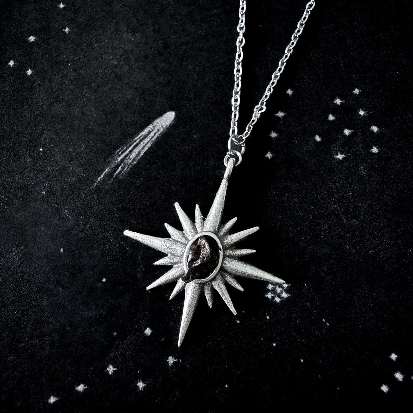 Silver star-shaped pendant necklace on a dark background