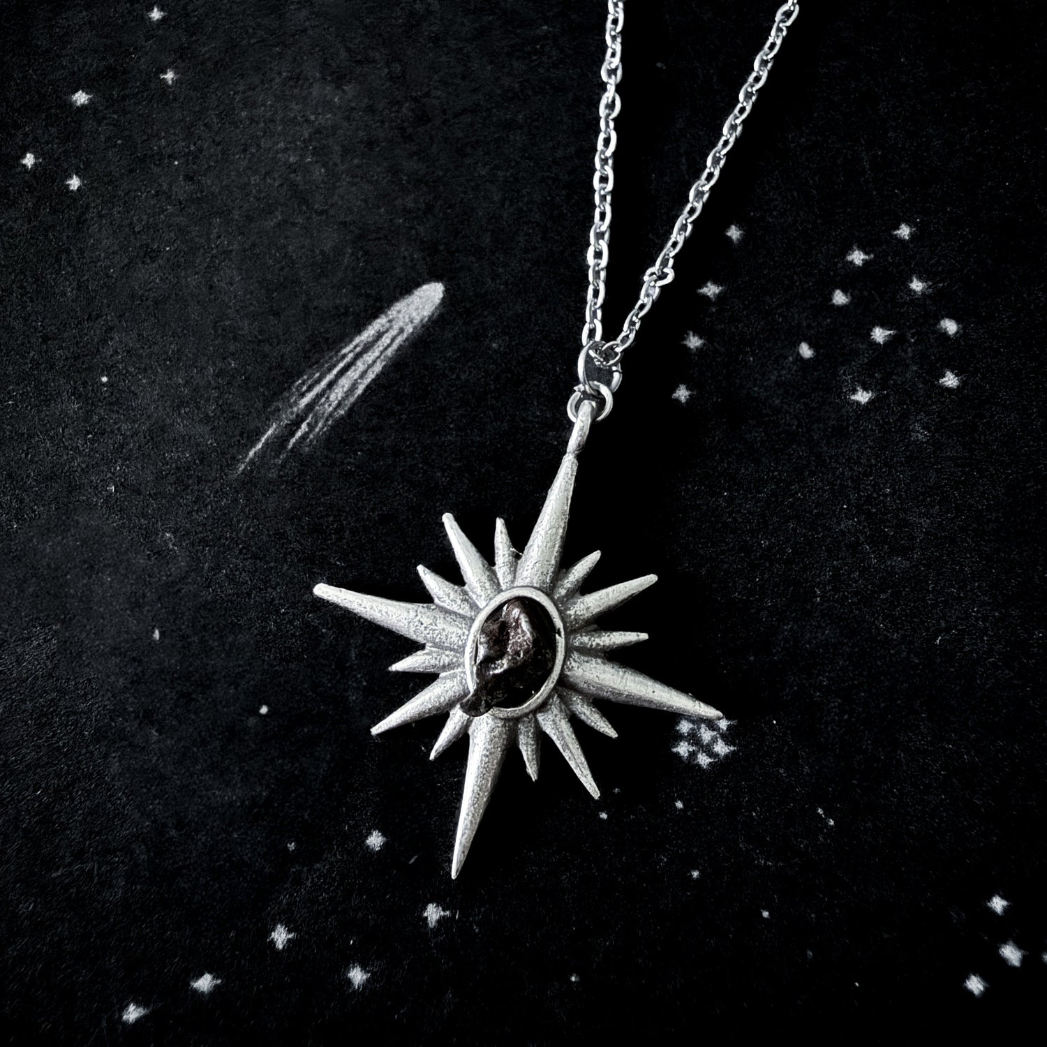 Silver star-shaped pendant necklace on a dark background