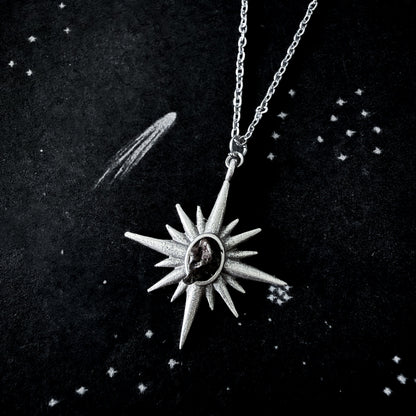 Silver star-shaped pendant necklace on a dark background