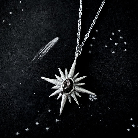 Silver star-shaped pendant necklace on a dark background