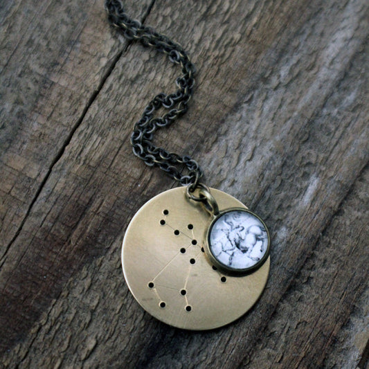 Bronze constellation necklace on a wooden background.