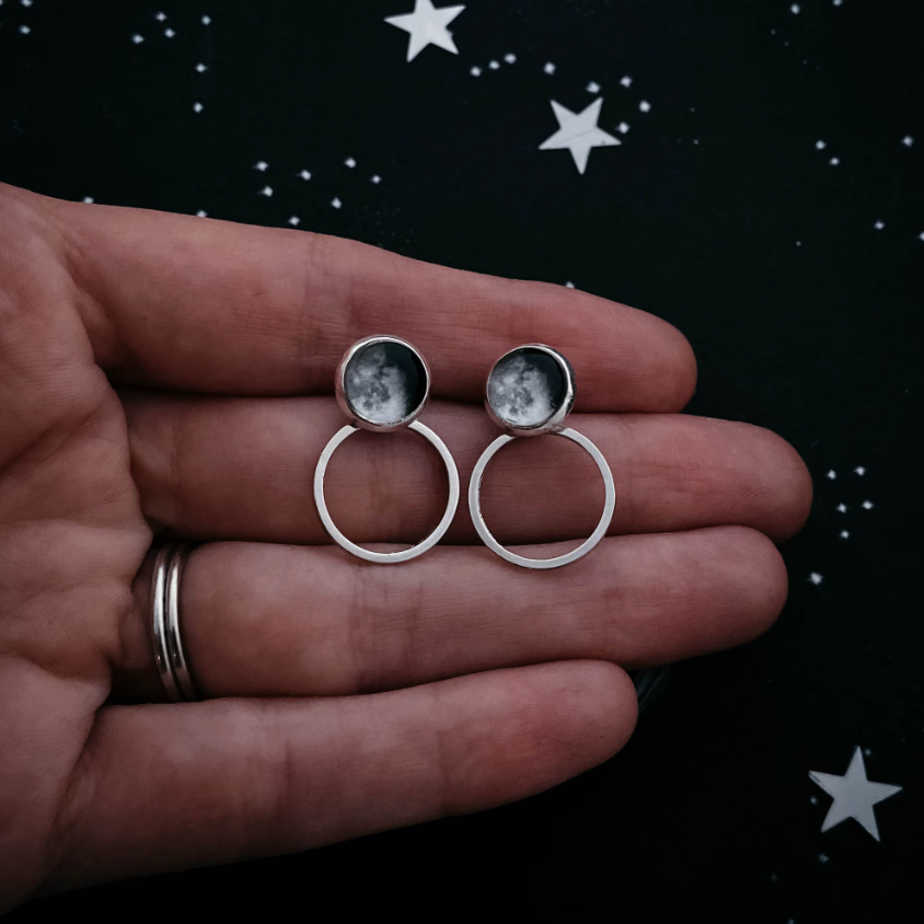 Circle Ear Jacket Earrings of waning gibbous moons being held by a hand