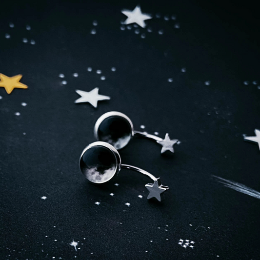 Star Ear Jacket earrings on a dark starry background.